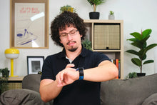 Load image into Gallery viewer, Man adjusting a smartwatch in a living room setting
