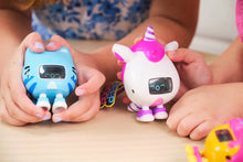 Load image into Gallery viewer, Two children holding robot toys, one blue and one pink with a unicorn design, on a light surface.