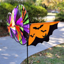 Load image into Gallery viewer, Colorful triple spinner with Halloween-themed bats and pumpkin design in a yard