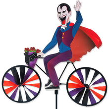 Load image into Gallery viewer, Side view of Premier Kites Colorful Dracula Whirlygig on a bicycle with spinning wheels.