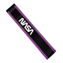 Load image into Gallery viewer, A black woven strap with a purple zigzag border and a white NASA logo printed on it, shown diagonally on a plain white background.