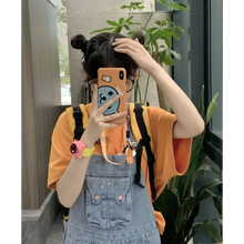 Load image into Gallery viewer, Person taking a mirror selfie wearing an orange shirt and denim overalls, holding a phone with a colorful case.