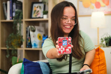 Load image into Gallery viewer, Woman holding a small electronic device in a casual indoor setting
