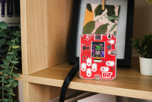 Load image into Gallery viewer, Red handheld gaming console with 'BIT' branding on a wooden shelf.
