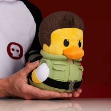 Load image into Gallery viewer, Chris Redfield Plush duck with a  green outfit held by a person against a red background
