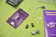 Load image into Gallery viewer, Electronic components and a purple circuit board on a green cutting mat with a booklet.
