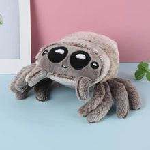 Load image into Gallery viewer, Plush toy resembling a spider on a light blue surface with a pink wall in the background
